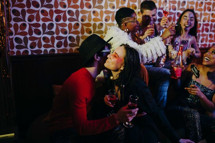 People enjoying drinks and laughing at a vibrant work Christmas party, embodying post-potluck celebration moments.