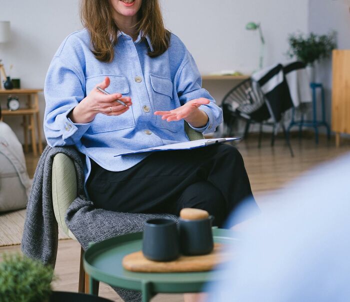 Medical professional in a blue shirt discussing health myths with gestures, seated in an office setting.