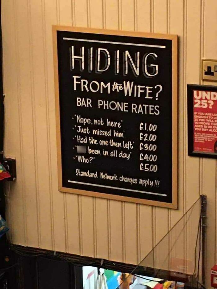 Chalkboard sign in a Scottish bar humorously listing phone rates for hiding from the wife.