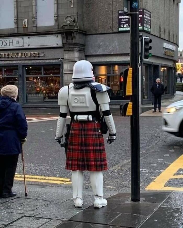 Stormtrooper in a kilt standing at a Scottish street corner, blending humor with iconic Scottish culture.