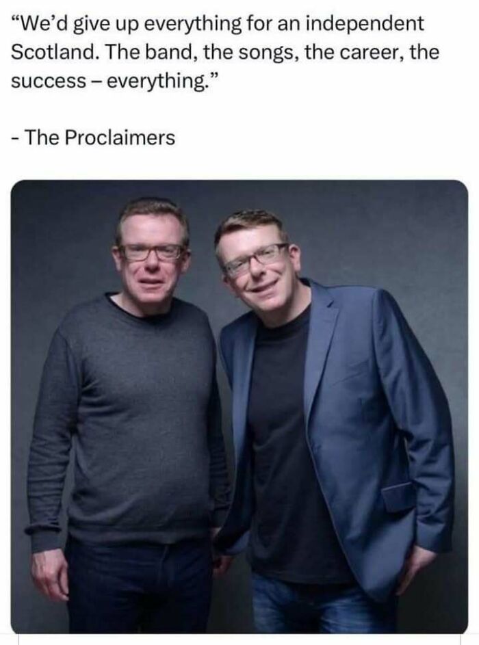 Two men standing together, one in a blazer and the other in a sweater, embodying Scottish culture and humor.