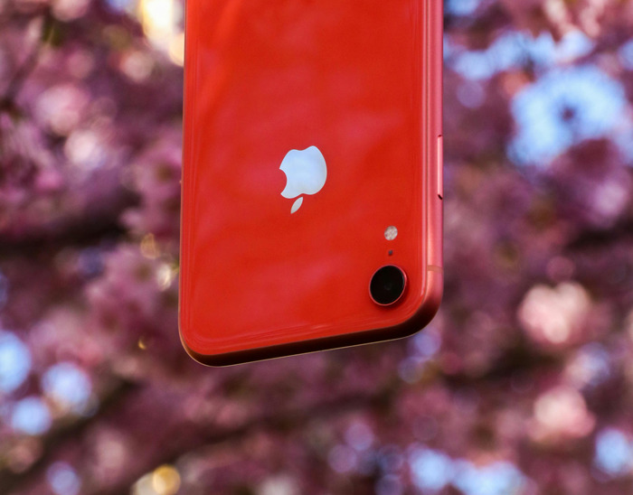 Red smartphone against a blurred background, capturing emerging trends for 2025.