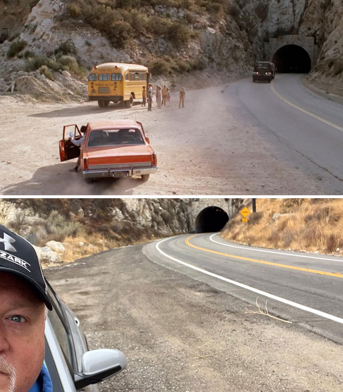 Famous tunnel location from a popular movie with a vintage car and school bus visible on a dusty road.