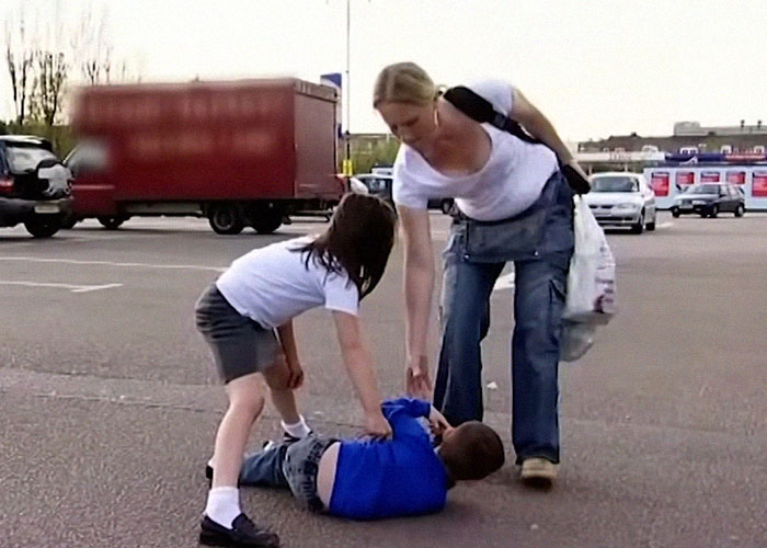 Woman assisting two children in a parking lot, reflecting reality TV show dynamics.