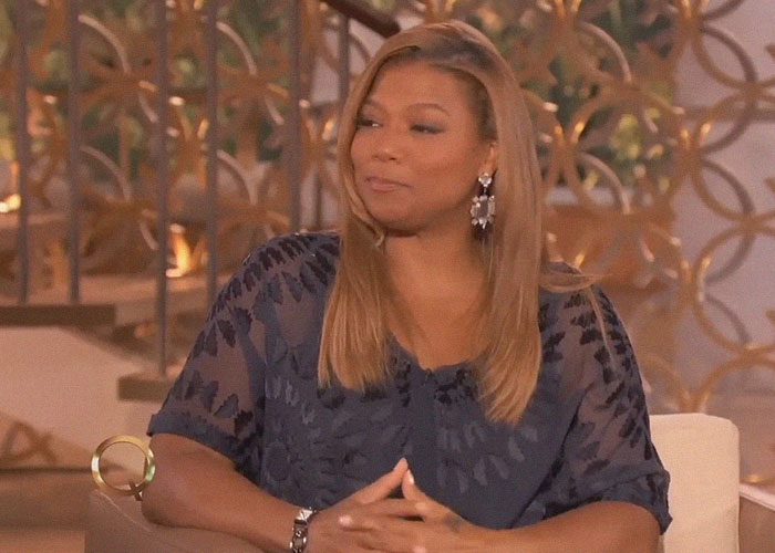 Person in a relaxed setting, wearing a navy blouse, discussing reality TV show insights.