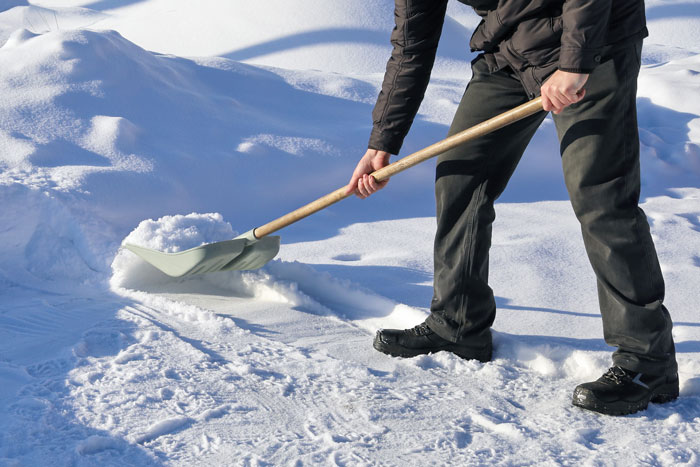 Person shoveling snow from a driveway.