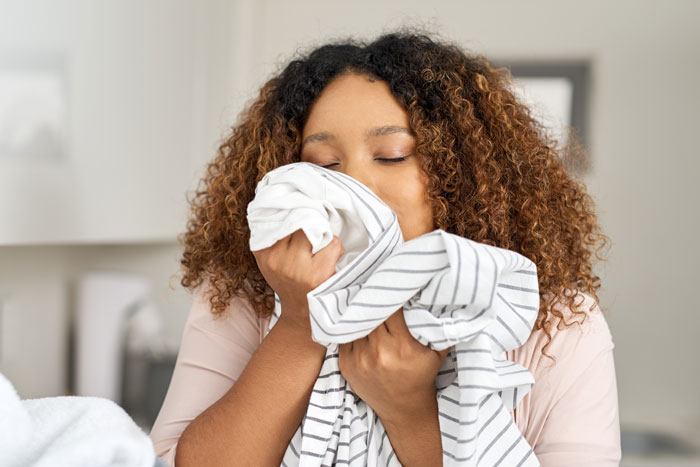 Woman confidently holding striped fabric, embracing calm and asserting boundaries.