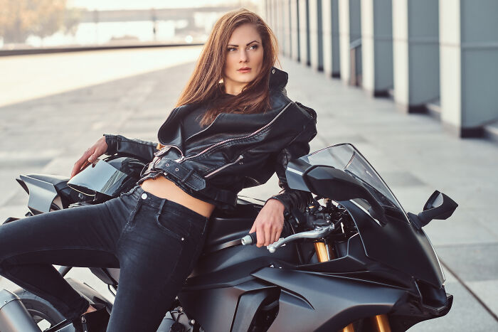 Woman in leather jacket posing on a motorcycle, representing Pinterest's yearly predictions for 2025 trends.