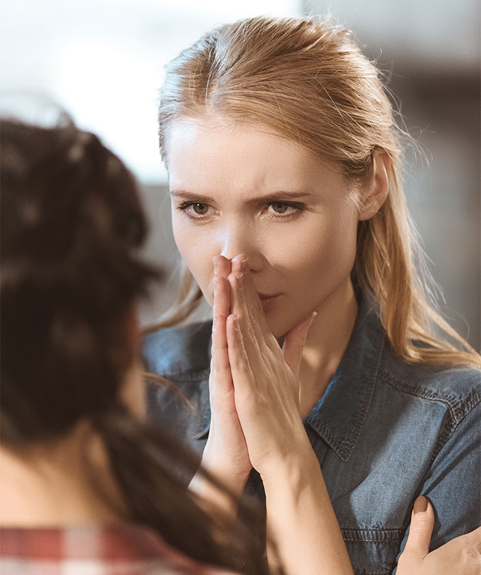A woman looking thoughtful with hands clasped, discussing lottery winnings with her sister. A woman looking thoughtful with hands clasped, discussing lottery winnings with her sister.