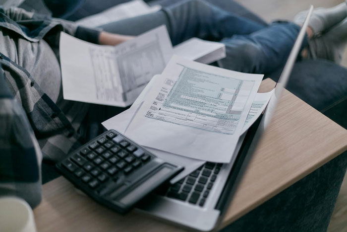 Calculator and papers on a desk, symbolizing clearing debt for many people. Calculator and papers on a desk, symbolizing clearing debt for many people.