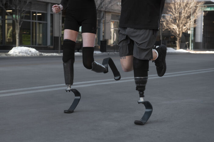 Runners with prosthetic legs in motion.