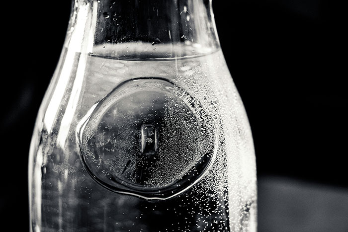 Close-up image of a glass bottle with condensation bubbles, highlighting unique Canadian design features.