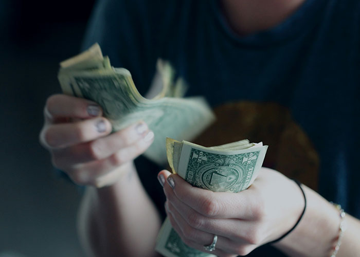 Person counting dollar bills, related to dumb reasons police were called.