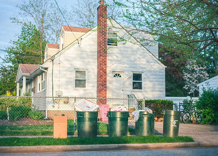 Residential street with garbage bins and recycling outside a house, illustrating times police were called for dumb reasons.