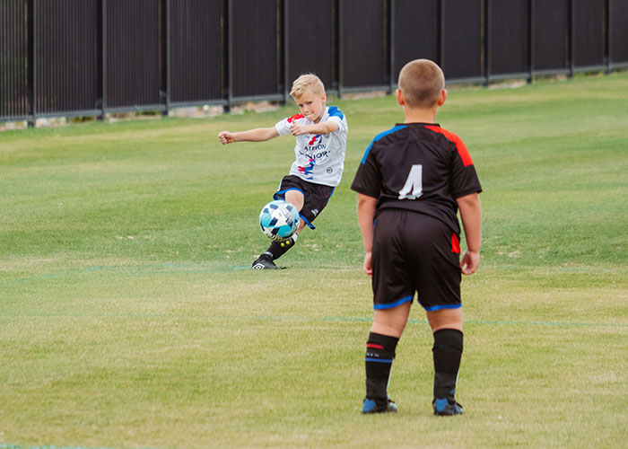 Two young boys playing soccer on a field, illustrating moments police were called on people for dumb reasons.