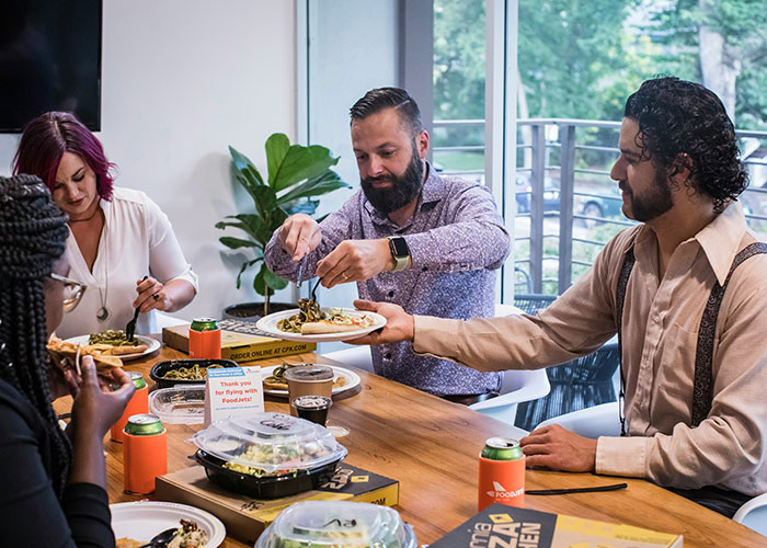 A group of people sharing food at a table, illustrating moments police were called on people for dumb reasons.