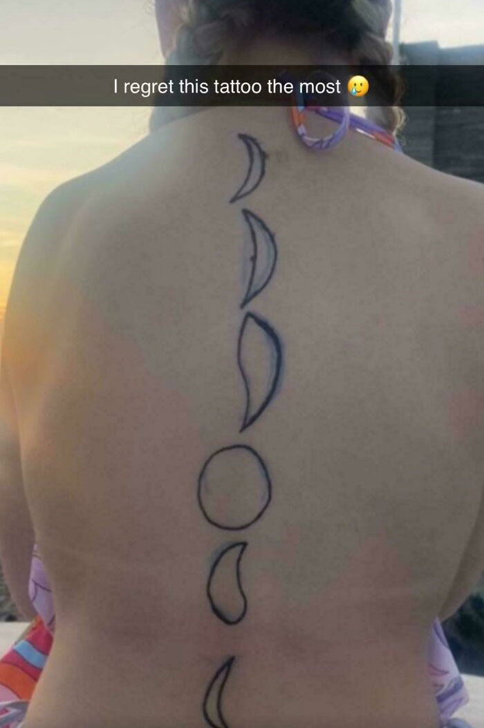 Back view of a person with a regrettable moon phase tattoo along the spine.