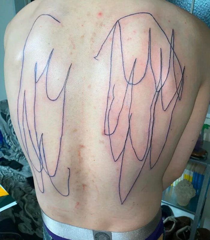 Back tattoo with uneven wing outlines, showcasing a poorly executed design.