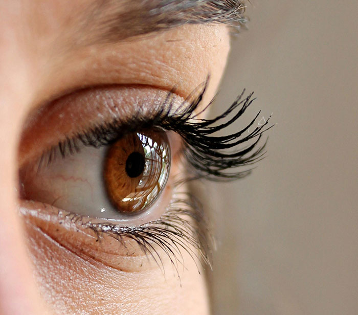 Close-up of a person's eye with long eyelashes, highlighting unique features and rare statistics.