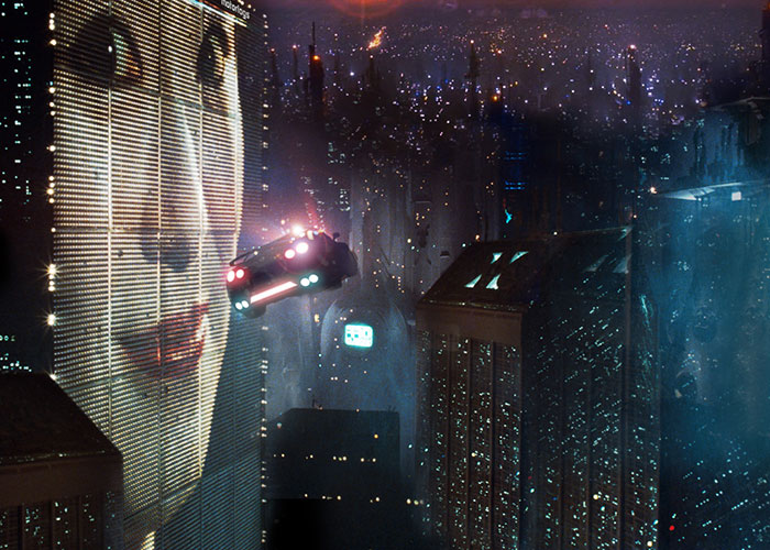 Futuristic cityscape with flying car and large digital screen, showcasing things people want that are actually terrible.