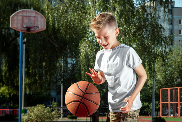 A boy playing basketball outside, with a focus on prioritizing sports activities over other commitments. A boy playing basketball outside, with a focus on prioritizing sports activities over other commitments.