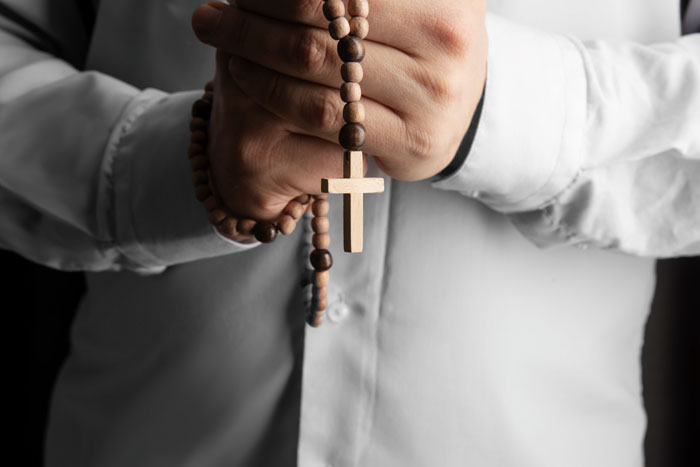Person holding a rosary, symbolizing family prioritizing Bible study over sports activities. Person holding a rosary, symbolizing family prioritizing Bible study over sports activities.