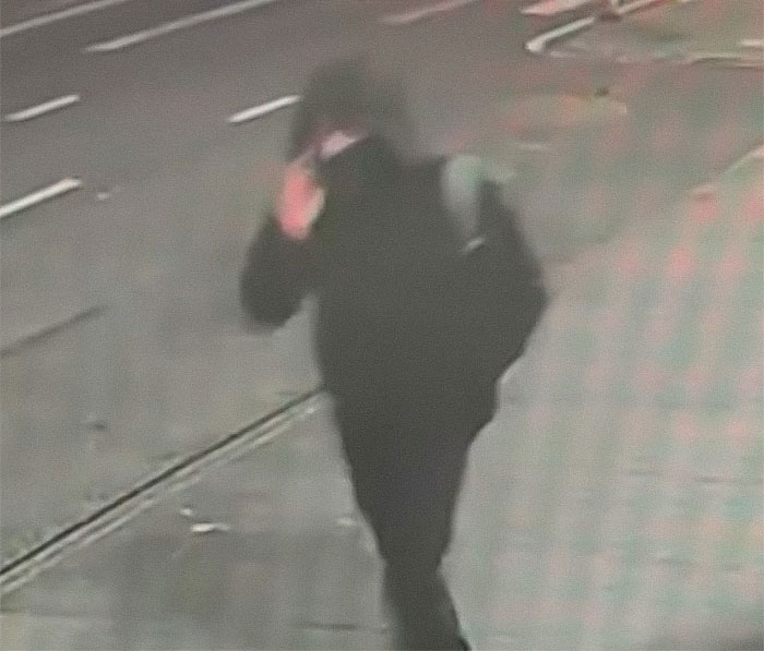CCTV footage of a person in dark clothing on a street, related to Brian Thompson&rsquo;s homicide case.