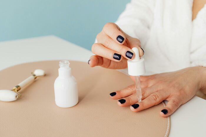 Person using serum dropper on nails, illustrating hygiene hacks.