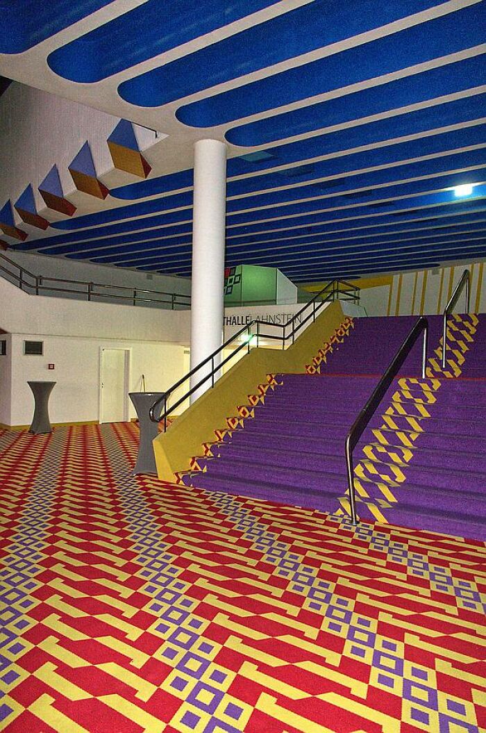 Colorful interior design resembling a video game environment, with geometric patterns on stairs and floor.