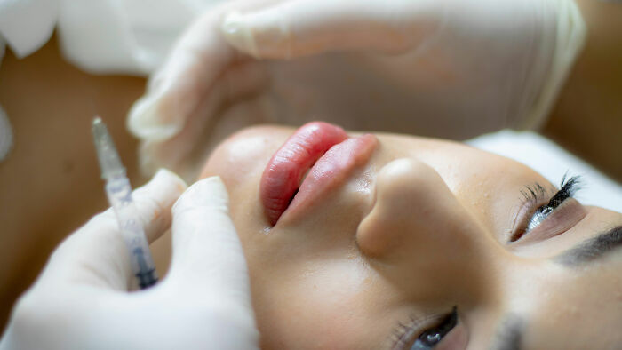 Person receiving a cosmetic injection in a clinic, highlighting the excessive cost of luxury treatments.