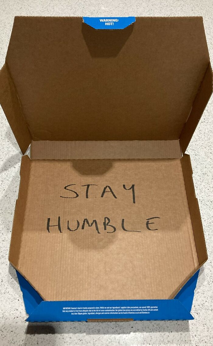 Open pizza box with "Stay Humble" written inside; part of official social media post showcasing humorous content.