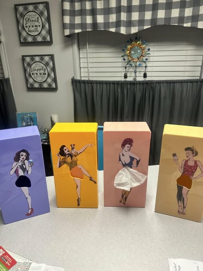 Second-hand discoveries: four vintage tissue holders with retro pin-up designs on a countertop.