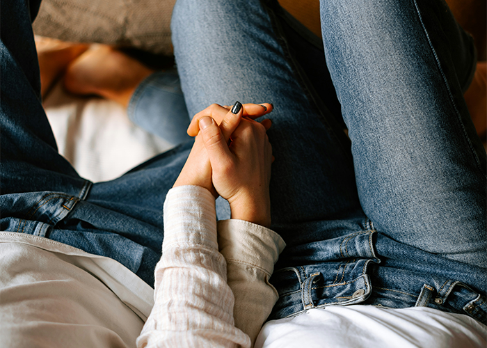 Couple holding hands, wearing casual denim jeans, symbolizing relationship challenges. Couple holding hands, wearing casual denim jeans, symbolizing relationship challenges.