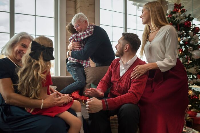 Family gathered in a cozy living room during the holidays, capturing a warm interaction and festive spirit.