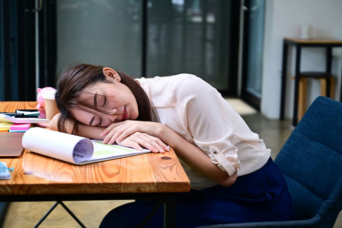 Woman exhausted at work, highlighting Japan's oppressive work rules. Woman exhausted at work, highlighting Japan's oppressive work rules.
