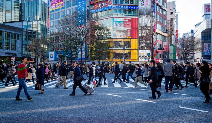 People crossing a busy street in Japan, showcasing cultural and work dynamics in an urban setting. People crossing a busy street in Japan, showcasing cultural and work dynamics in an urban setting.