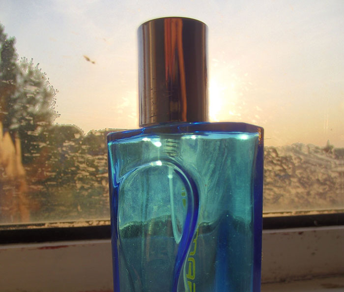 Blue perfume bottle against a sunlit window, linked to disappointing Christmas gifts.