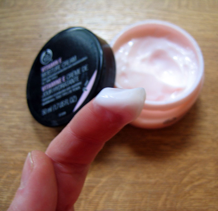 Finger dipped in skincare cream during Secret Santa gift exchange.