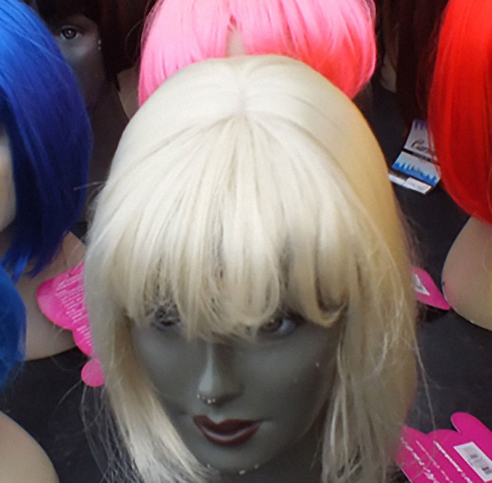 Mannequin heads with colorful wigs, illustrating bad luck in Secret Santa exchange.