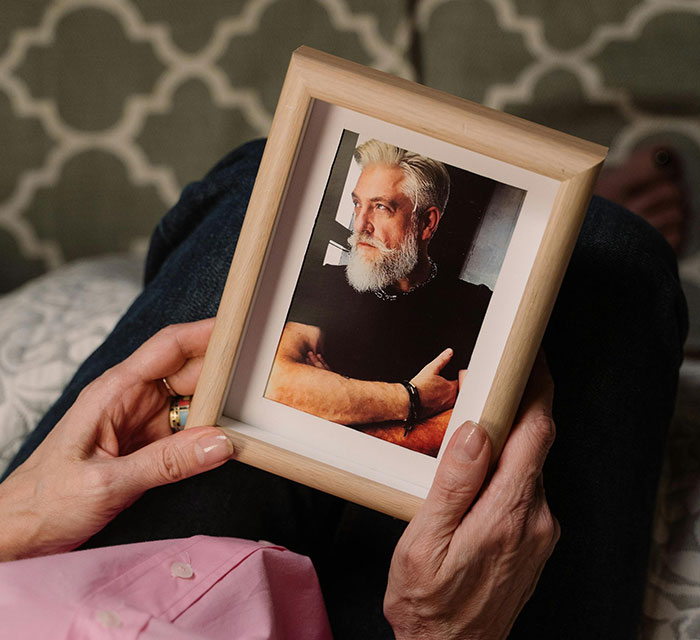 Person holding a framed photo, relevant to Secret Santa mishaps.