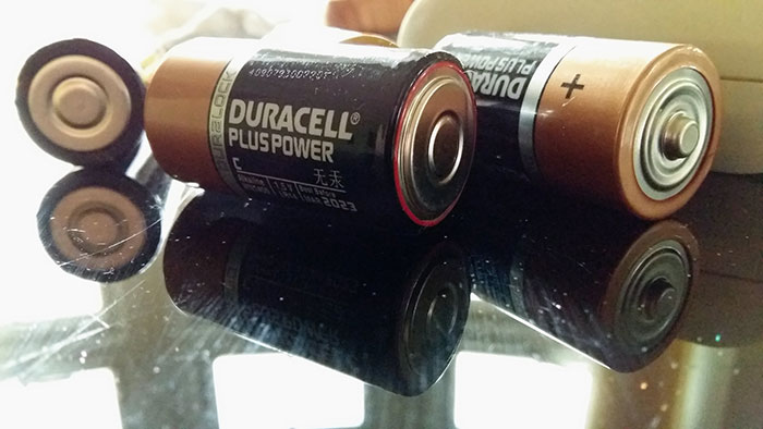 Duracell batteries on a reflective surface, representing unlucky Secret Santa gift choice.