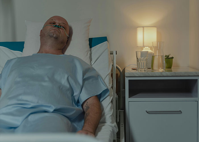 A man in a hospital bed with an oxygen tube, highlighting worst things happened at Christmas.