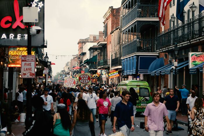 Busy street scene with a crowd and neon signs in a city, highlighting challenges of a worst city country trip.