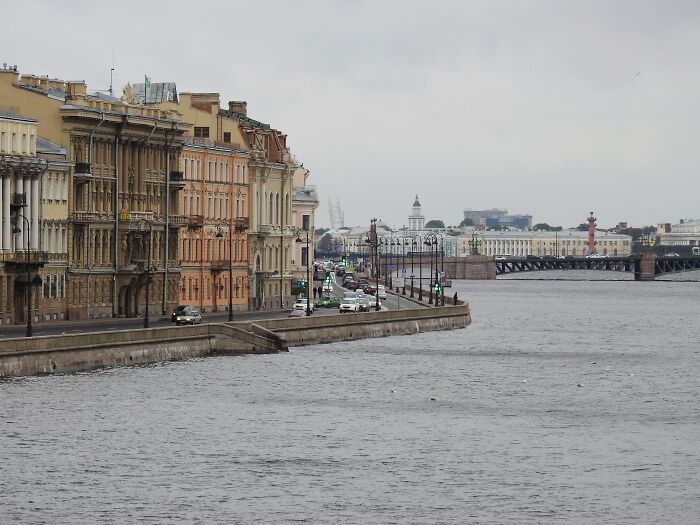 Cityscape with historic buildings along a river under a cloudy sky, featuring the keyword "worst-city-country-trip."