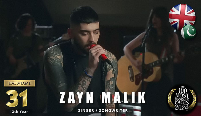 Singer onstage with tattoos, holding a microphone, representing the rankings of the most handsome men by independent critics.