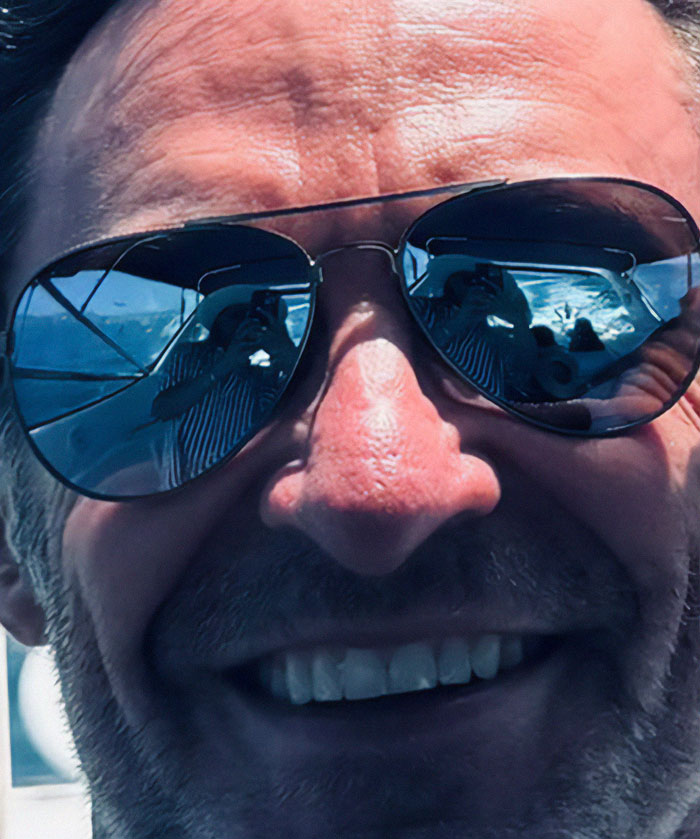 Man in aviator sunglasses with reflections of a person, sparking rumors. Man in aviator sunglasses with reflections of a person, sparking rumors.