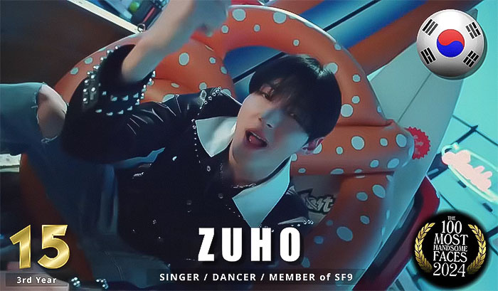 Korean artist ranked among the most handsome men of 2024, sitting in a colorful setting.