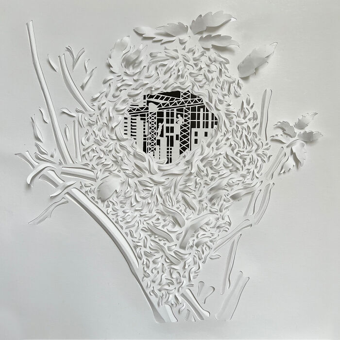Intricate paper cut design depicting urban architecture surrounded by ornate leaf patterns, highlighting tree-less existence.