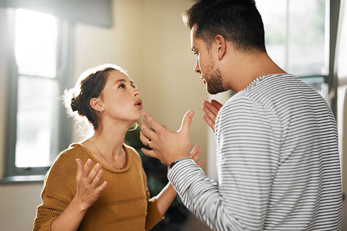 Man and woman arguing indoors, representing family feud over a heirloom.