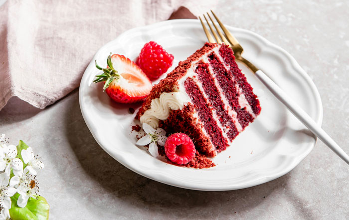 Slice of red velvet cake with fresh berries on a white plate, symbolizing sobriety milestone celebration. Slice of red velvet cake with fresh berries on a white plate, symbolizing sobriety milestone celebration.